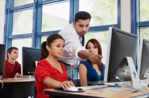 A man and two women working on computers.