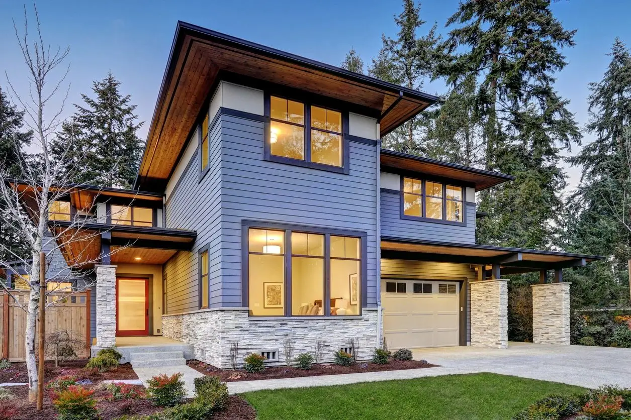 A blue house with a stone driveway and garage.